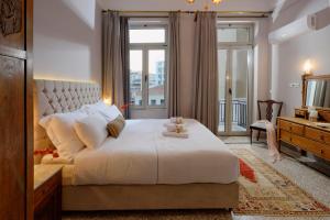 a bedroom with a large white bed and a window at Athenian Vintage Apartments in Athens