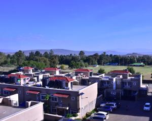 a group of buildings with cars parked in a parking lot at Essy's Furnished Homes Nakuru with pool & GYM in Nakuru