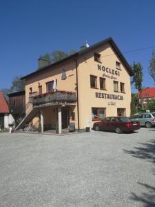 a building with a car parked in a parking lot at Srebrny Świerk in Wambierzyce
