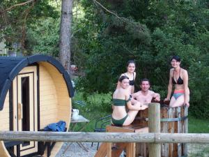 a group of people in bathing suits sitting on a barrel at Chalets du Bois de Vache in Le Poët-Célard