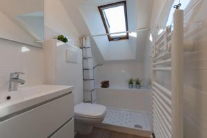 a bathroom with a toilet and a sink and a window at Haus Kuen in Merano +27 photos