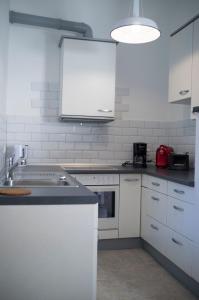 eine Küche mit weißen Schränken und einem Waschbecken in der Unterkunft Quadenhof in Düsseldorf