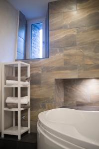 a bathroom with a white tub and a wooden wall at Quadenhof in Düsseldorf