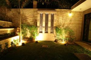 un cortile di notte con una porta e alcune piante di ​juSTa Gurgaon a Gurgaon