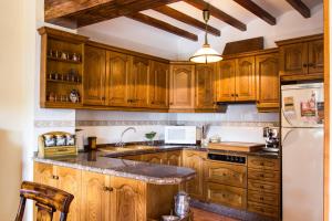 a kitchen with wooden cabinets and a white refrigerator at Casa Rosalía in Ibi