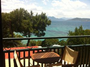 a balcony with chairs and a view of the ocean at Danae Hotel in Egina