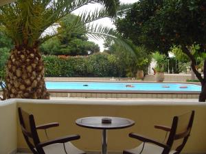 a table and chairs in front of a swimming pool at Danae Hotel in Egina