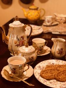 una mesa con tazas de té y galletas en ella en Princess Anne Book Lovers Inn en Princess Anne
