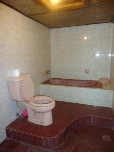 un baño con inodoro y bañera en Pondok Kecil Bungalow, en Ubud