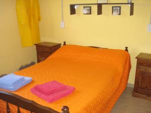an orange bed with two towels on top of it at Finca La Virreinita in Panaholma