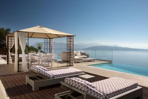 einen Pool mit Pavillon und Stühlen neben dem Wasser in der Unterkunft My Villa Corfu in Nisaki