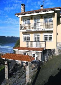 a large house with a balcony and a view of the ocean at Apartamentos Bellavista in Artedo