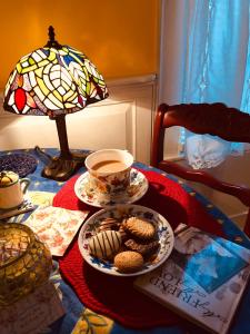 una mesa con una taza de té y un plato de galletas en Princess Anne Book Lovers Inn, en Princess Anne
