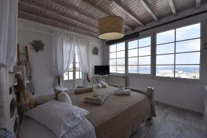 a bedroom with a bed and a couch and windows at Ftelia View in Elia