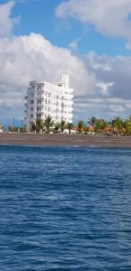 un gran edificio blanco en la playa junto al agua en Playa La Barqueta , Las Olas Tower Front, en David