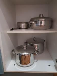 tres ollas y sartenes en estanterías en una cocina en Casa Dulce, en Gran Tarajal
