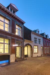 a group of buildings on a brick street at Zenden Hotel Maastricht in Maastricht