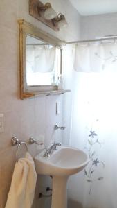 een badkamer met een wastafel en een spiegel bij Cabañas Pyracantha in Esquel