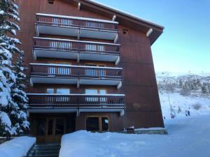 un bâtiment avec de la neige devant lui dans l'établissement Cembros 2, à Méribel