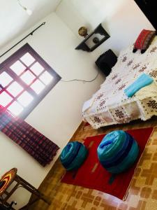 um quarto com uma cama com esferas azuis no chão em tamazirt surf house em Taghazout