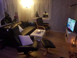 a living room with a couch and a table at Lille Villa Severin in Mosterhamn