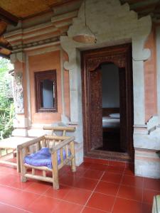 a wooden bench sitting on the porch of a house at Pondok Kecil Bungalow in Ubud