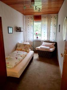 MengerskirchenにあるGrosses Ferienhaus im Westerwaldのベッド2台と窓が備わる小さな客室です。