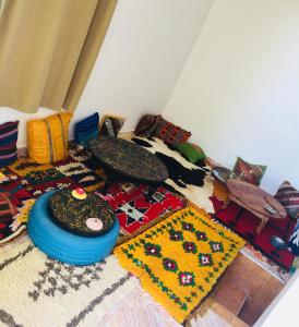 a room with lots of carpets on the floor at tamazirt surf house in Taghazout