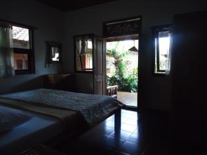 a bedroom with a bed and a door to a patio at Pondok Kecil Bungalow in Ubud +5 photos