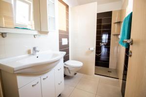 a bathroom with a white sink and a toilet at Apartment Milka 1 in Njivice +48 photos