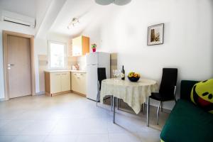 a kitchen and dining room with a table and a refrigerator at Apartment Milka 1 in Njivice