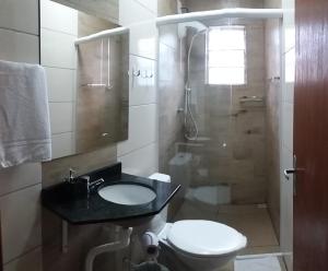 a bathroom with a toilet and a sink and a shower at Hotel Majestic in Pelotas