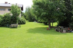 un parque con una mesa de picnic y un árbol en Apartments Krassnig, en Krumpendorf am Wörthersee