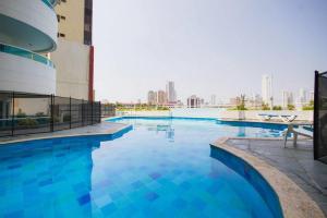 a large swimming pool with blue water in a building at Torres del Lago Apartamentos in Cartagena de Indias