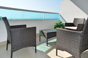 a balcony with two chairs and a table on a roof at Torres del Lago Apartamentos in Cartagena de Indias