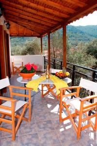 a patio with a table and chairs on a balcony at Artemis Bungalows in Stafylos