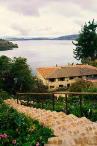 a house on a hill next to a body of water at Hotel Refugio Pozo Azul in Aquitania