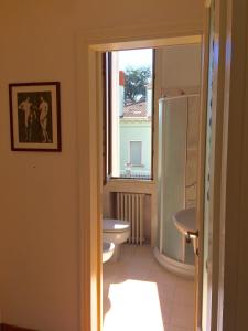 a bathroom with a toilet and a window at CASA MAGNOLIA in Venice-Lido