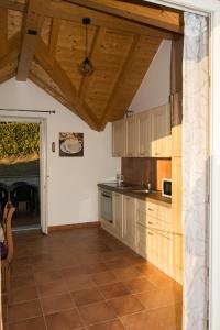 a large kitchen with wooden cabinets and a table at Casa giardino panoramico in Cannero Riviera