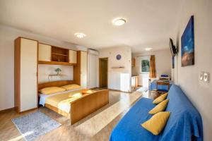 a bedroom with two beds and a blue couch at Apartments Slavica in Luka