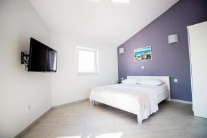 a bedroom with a bed and a flat screen tv at Colic in Njivice