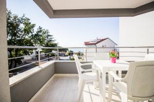 a white table and chairs on a balcony with a view at Colic in Njivice