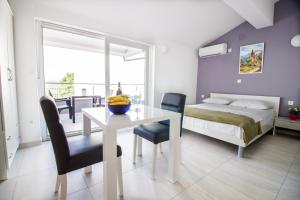 a bedroom with a table and a bed and a bed and a room at Colic in Njivice