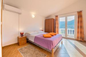 ein Schlafzimmer mit einem Bett und einem großen Fenster in der Unterkunft Apartments Slavica in Luka