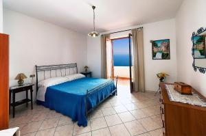 una camera con letto e copriletto blu di Casa Nancy ad Amalfi