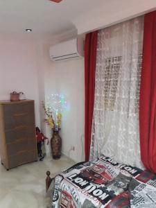 a bedroom with a bed and a red curtain at Appartement Akid Lotfi Oran in Oran