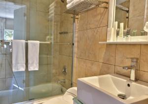 a bathroom with a shower and a sink and a toilet at Beacon South Beach Hotel in Miami Beach