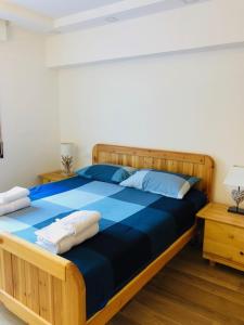 a bedroom with a large wooden bed with blue sheets at LA TANA DEL LUPO in Roccaraso +27 photos