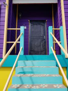 a purple and blue house with a door at Slo-N-Ez Villa Terrace (Ocean View) in Caye Caulker