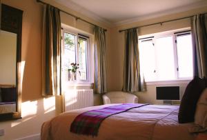 1 dormitorio con 1 cama y 2 ventanas en Broomfields Country House, en Melrose
